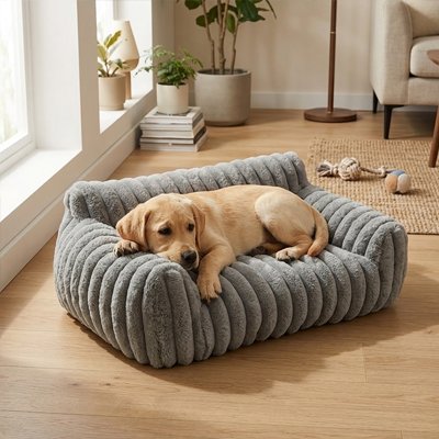 Chiot endormi dans un canapé pour chien gris aux rebords moelleux