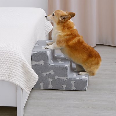 Escalier pour chien gris à motif os, un corgi monte sur le lit