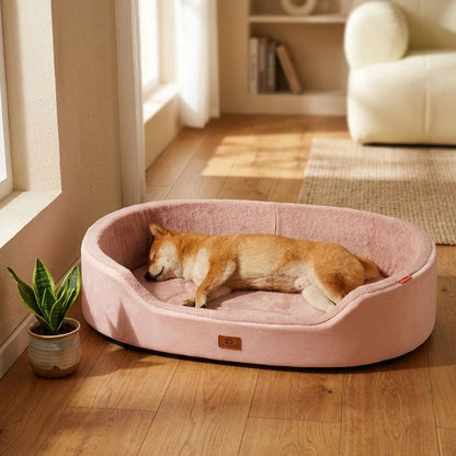 Panier pour chien rose avec un petit chien roux endormi