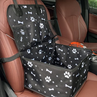 Rehausseur pour chien noir à motifs os et pattes fixé sur un siège de voiture